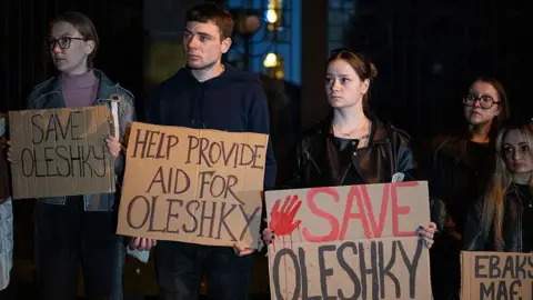 Getty Images Activists hold placards with slogans during a rally in support of residents of Oleshky, Kherson region, calling on the international community to draw attention to the humanitarian situation in the Russian-occupied city.
