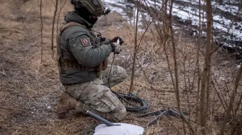 Reuters  A Ukrainian serviceman of 47th brigade prepares a Starlink satellite internet systems at his positions at a front line, in February 2024 