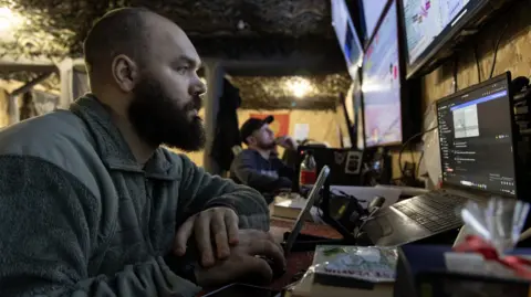 Getty Images A close up of a Ukranian soldier surrounded by computer screens