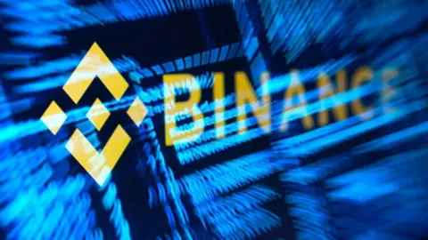 Reuters Binance logo in yellow over stylised and hacker code in blue